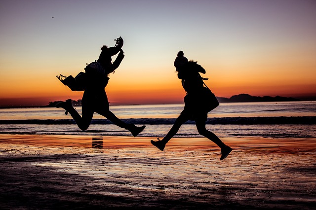 dvě skákající dívky na pláži.jpg